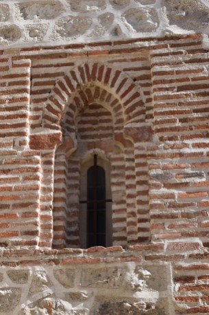 Detalle de un vano de la torre con doble arco de herradura apuntado de ladrillo enmarcado por alfiz.